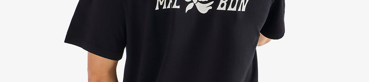 Person wearing a black t-shirt with white text and graphics on the back, standing against a white background.