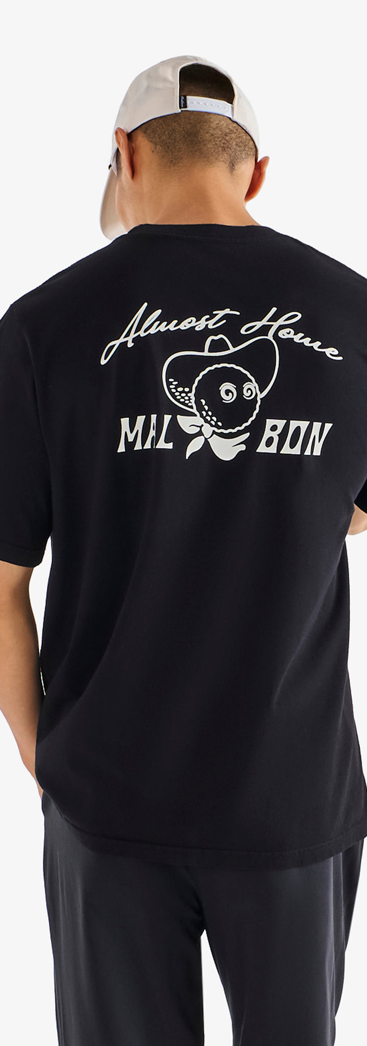 Person wearing a black t-shirt with white text and graphics on the back, standing against a white background.