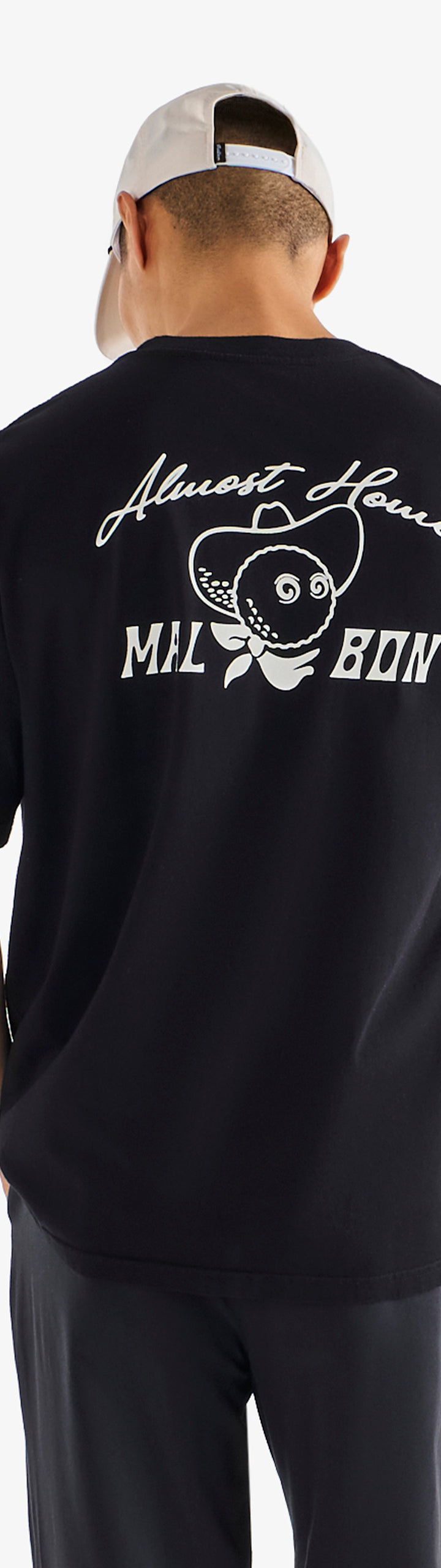 Person wearing a black t-shirt with white text and graphics on the back, standing against a white background.